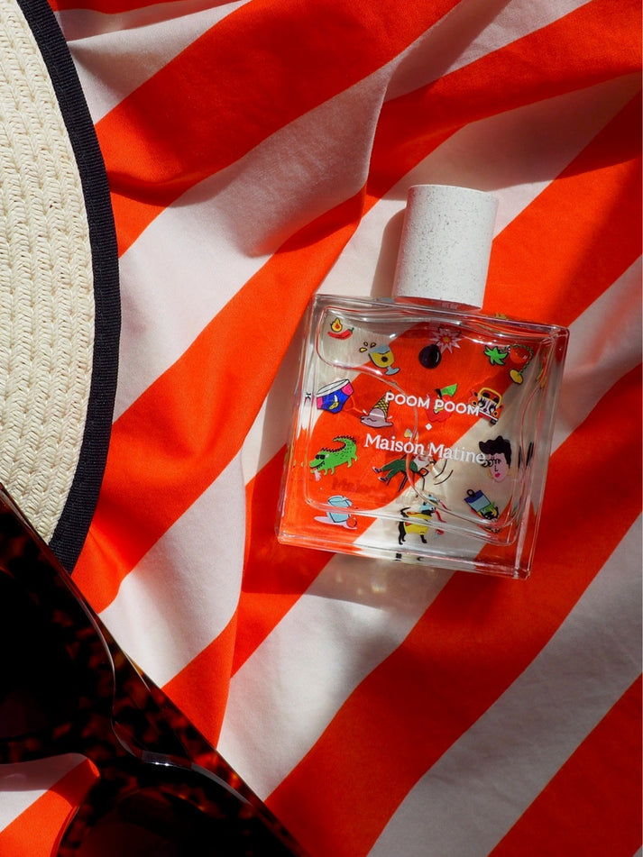 Clear eau de parfum bottle with cork stopper and colorful character label