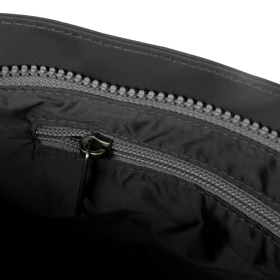 Interior view of charcoal gray nylon crossbody bag with zip pocket and zipper pull