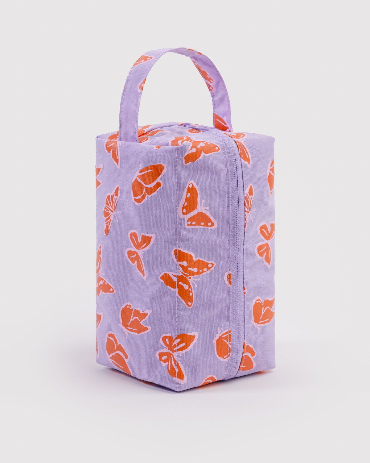 Dopp kit with lavender exterior and orange butterfly print, zip-top and carry handle