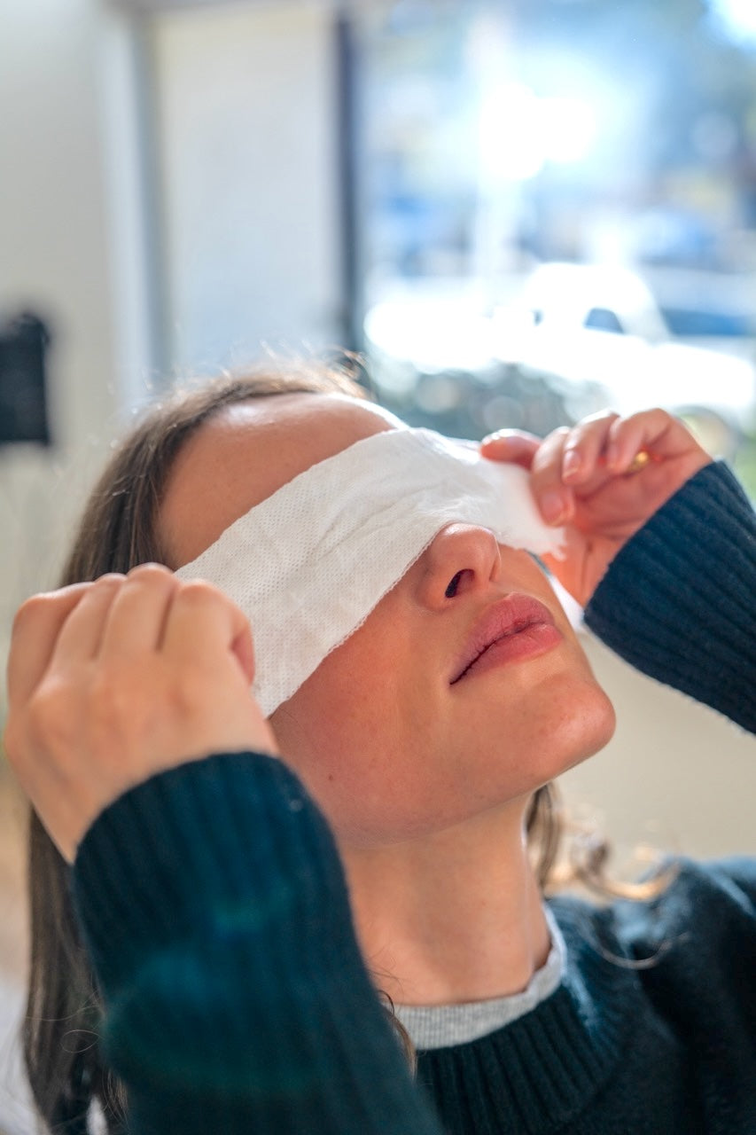 Aromatherapy eye cover on face: white cloth mask over closed eyes