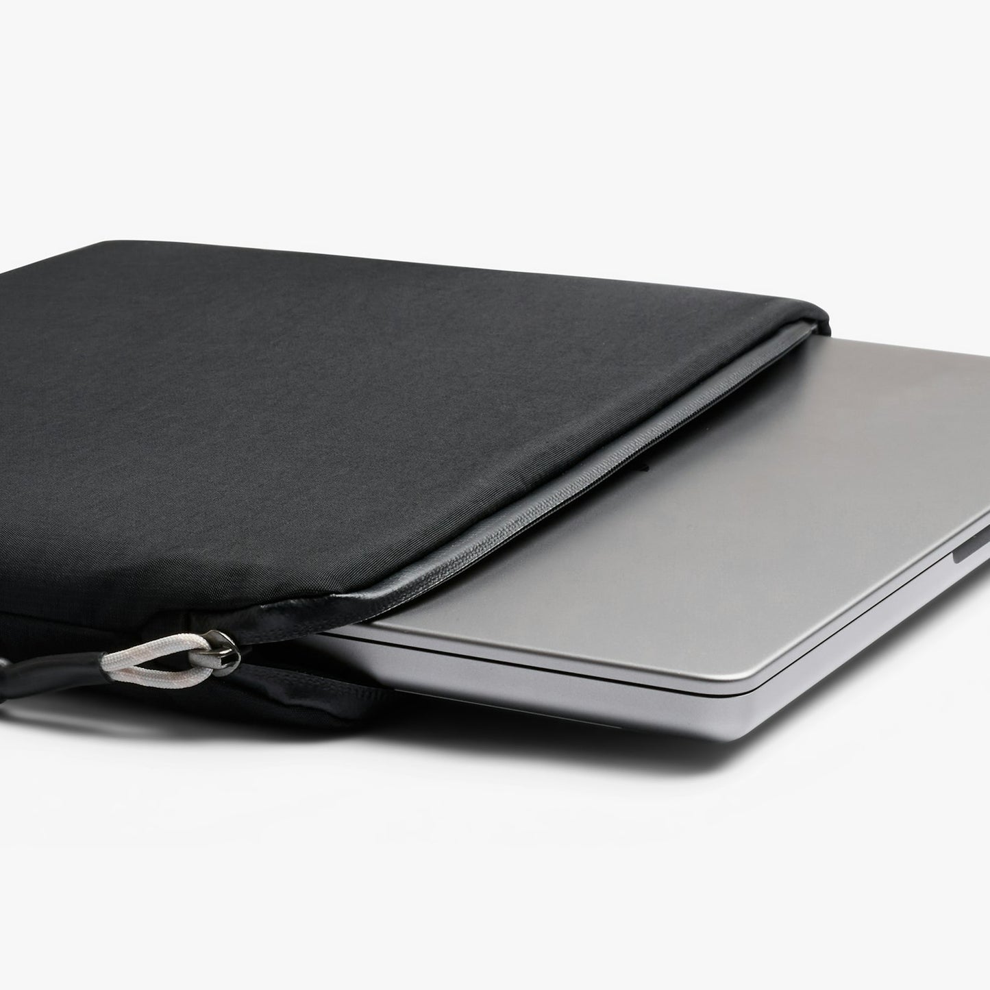 Black slim laptop sleeve open with silver zipper; laptop fits inside