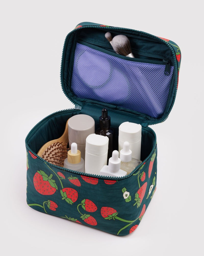 Large strawberry-print cosmetic case open with organizer pockets and bottles inside.