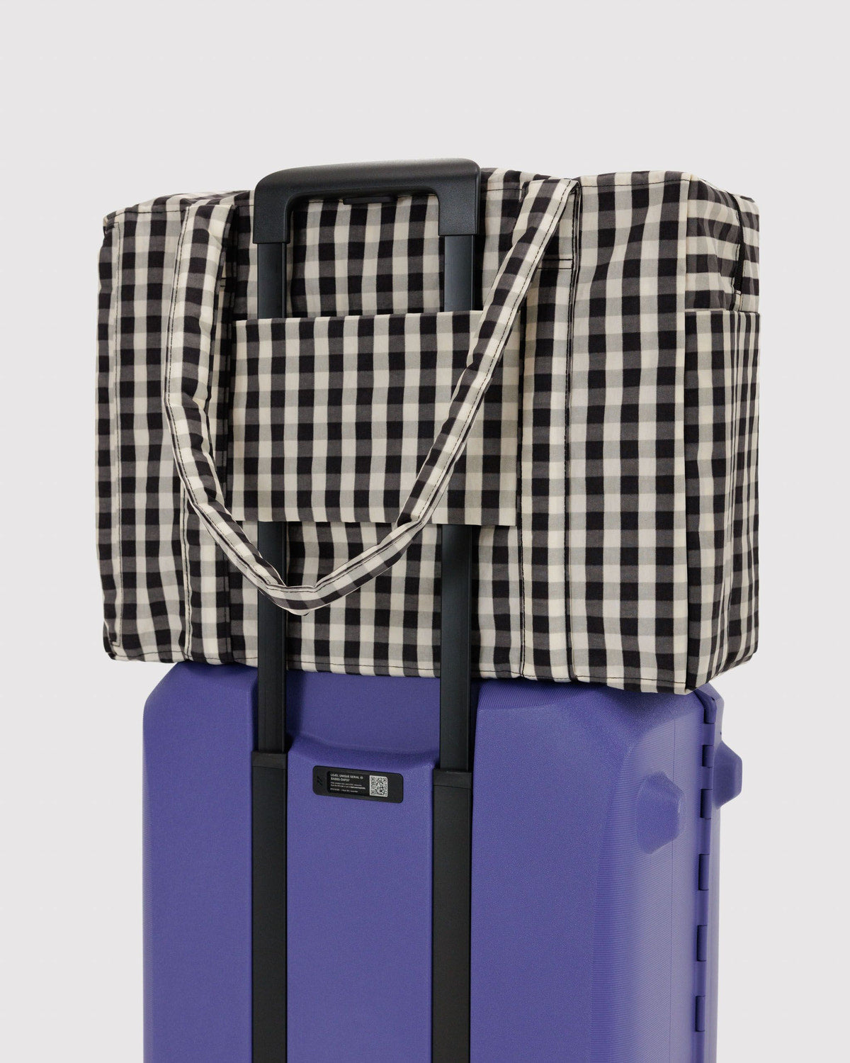 Carry-on bag in black-and-white gingham with shoulder strap and front pocket