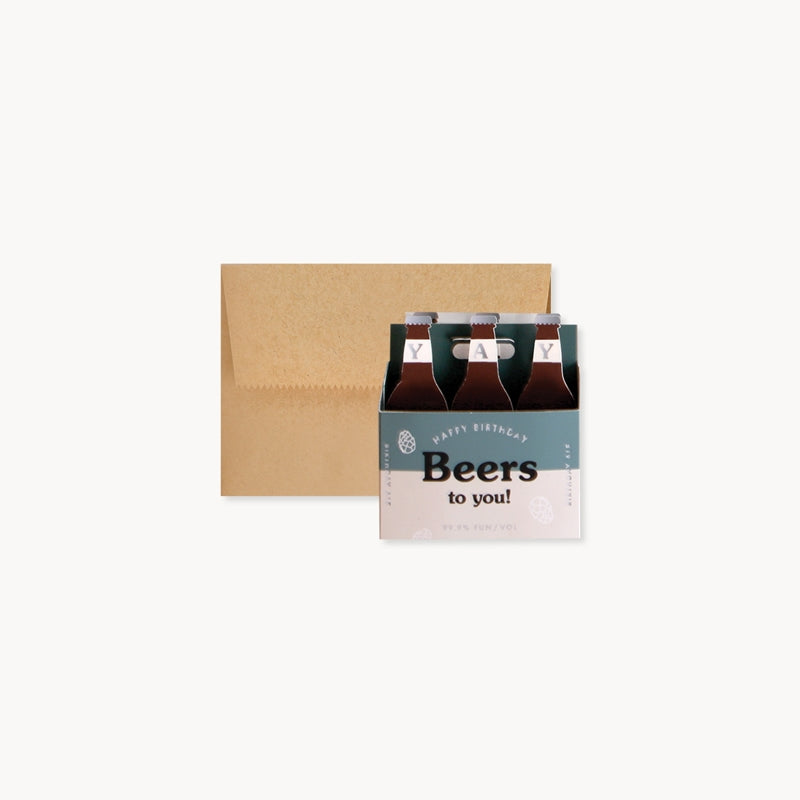 Pop-up birthday card with beer-bottle top row and kraft envelope in view