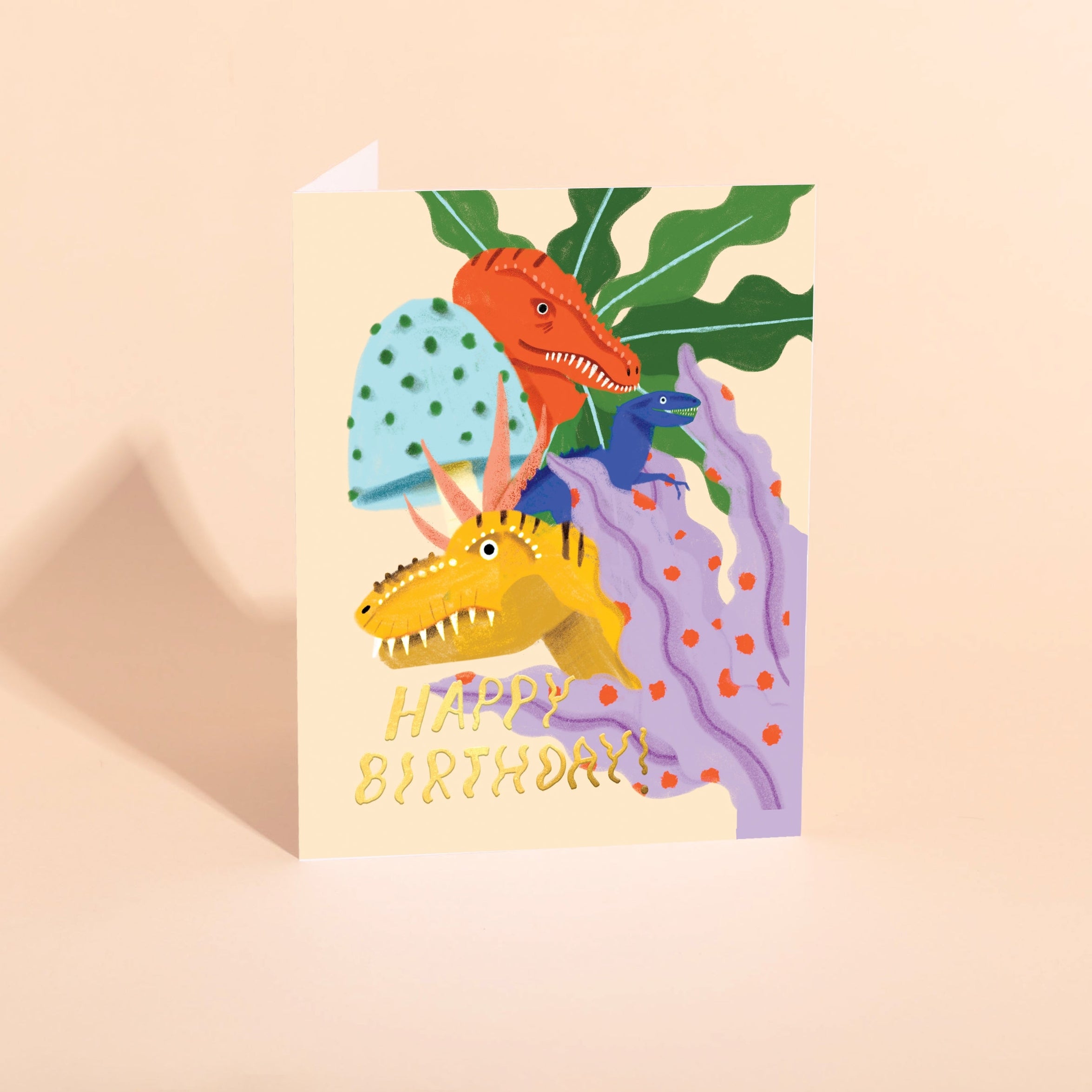 Dinosaur birthday foil card with T. rex, raptor, and Happy Birthday text