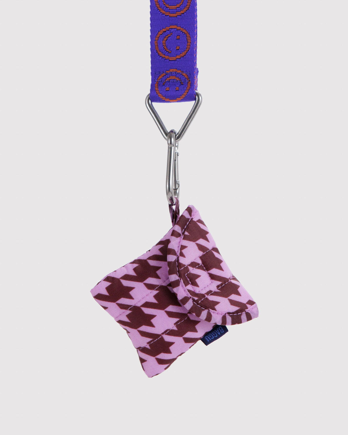 Houndstooth puffy earbuds case with blue lanyard and metal clip, hanging from strap