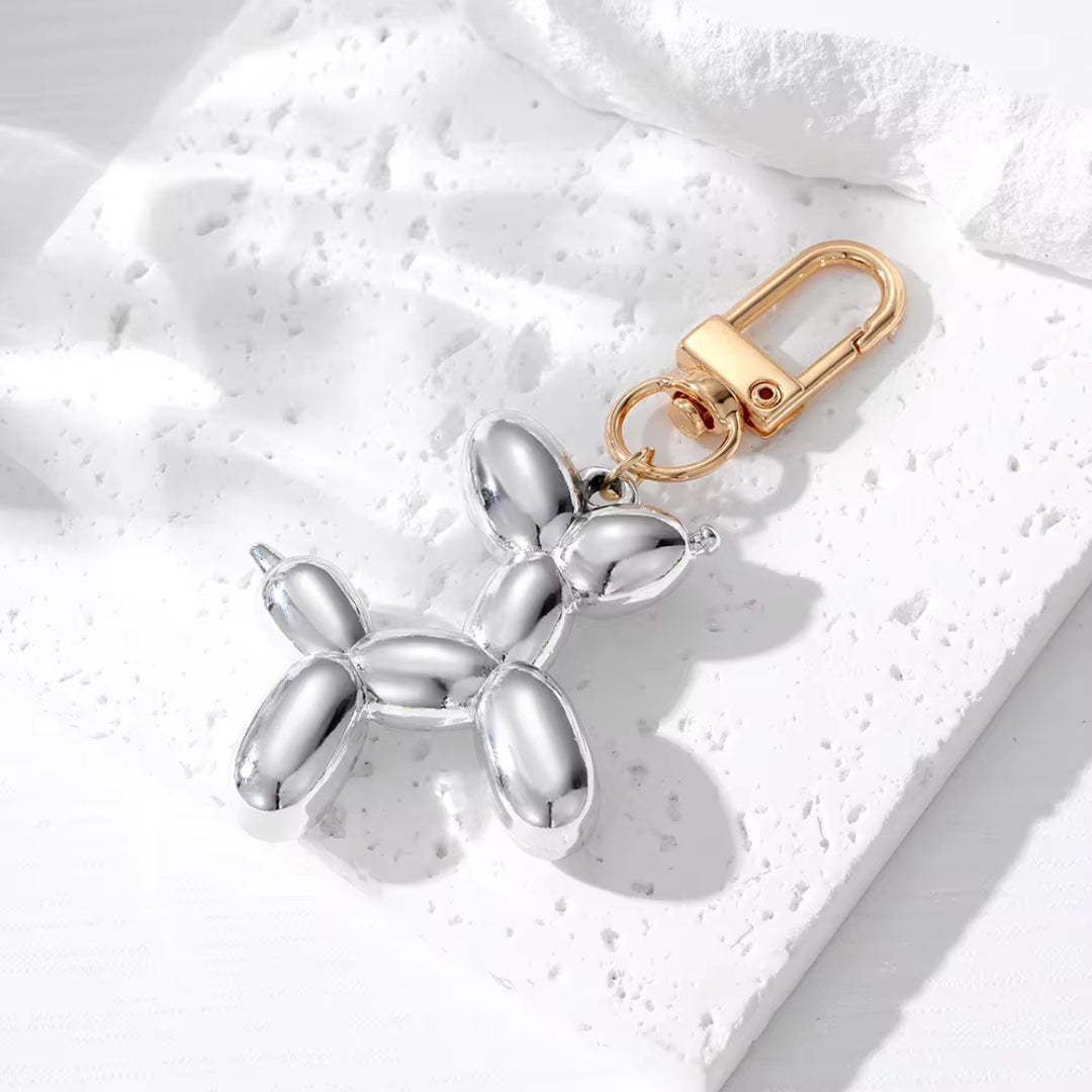 Silver metallic balloon dog keychain with gold clasp and split-ring attachment