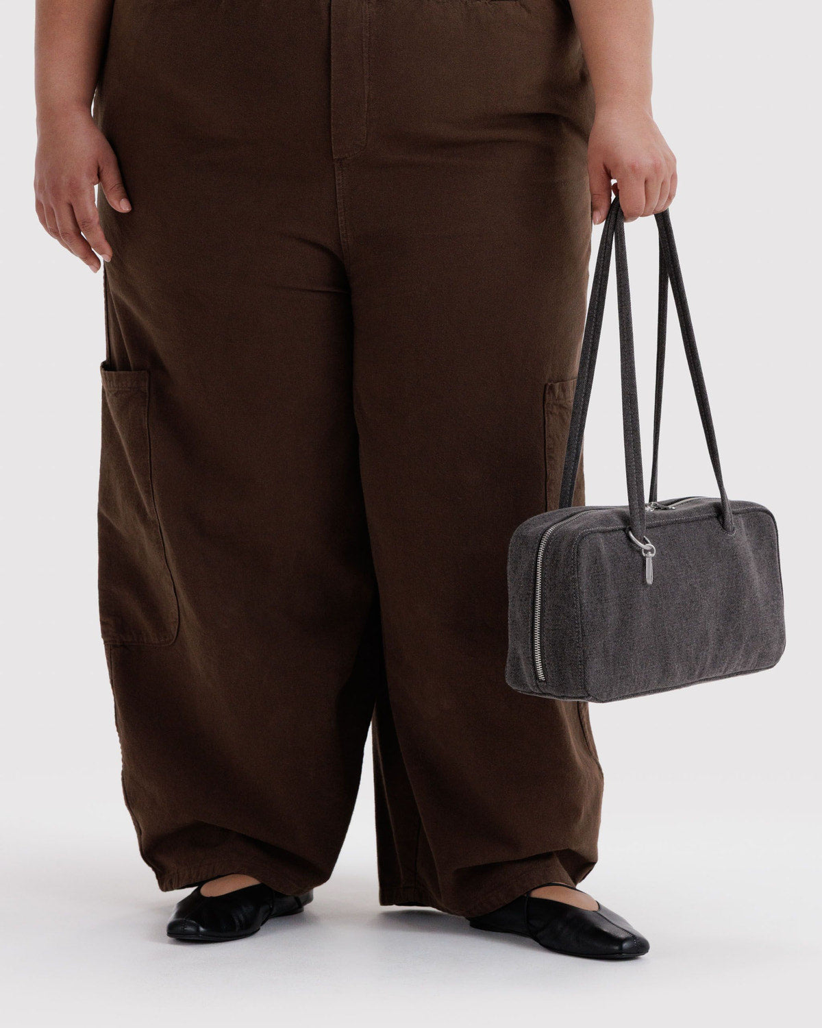 Washed black denim bowler bag with short handles and exterior zip pocket
