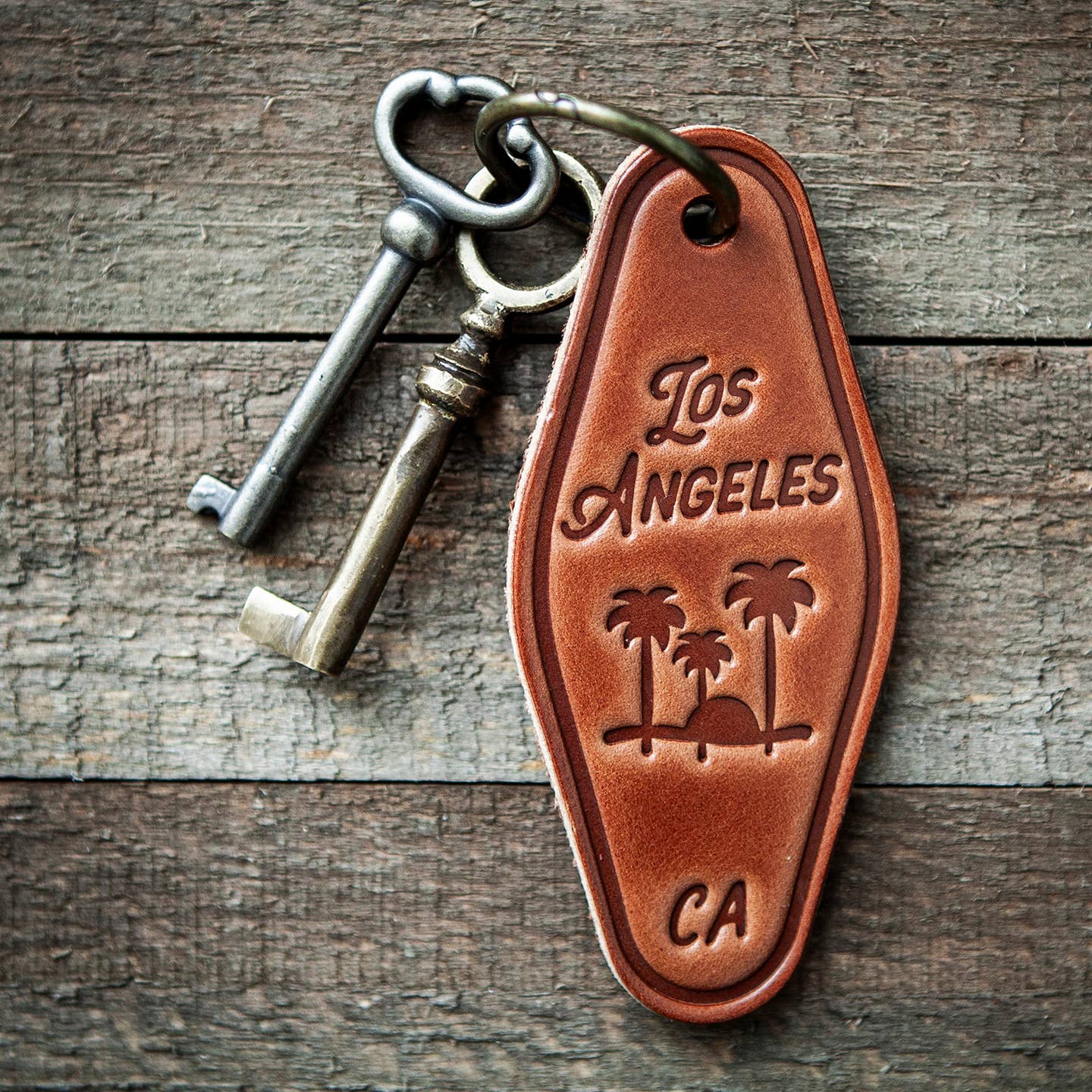Brown leather keychain with Los Angeles text, palm trees, and CA on a tag