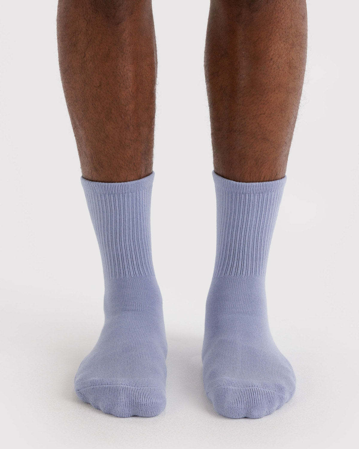 Ribbed mist blue socks on feet with ribbed cuff and rounded toe.