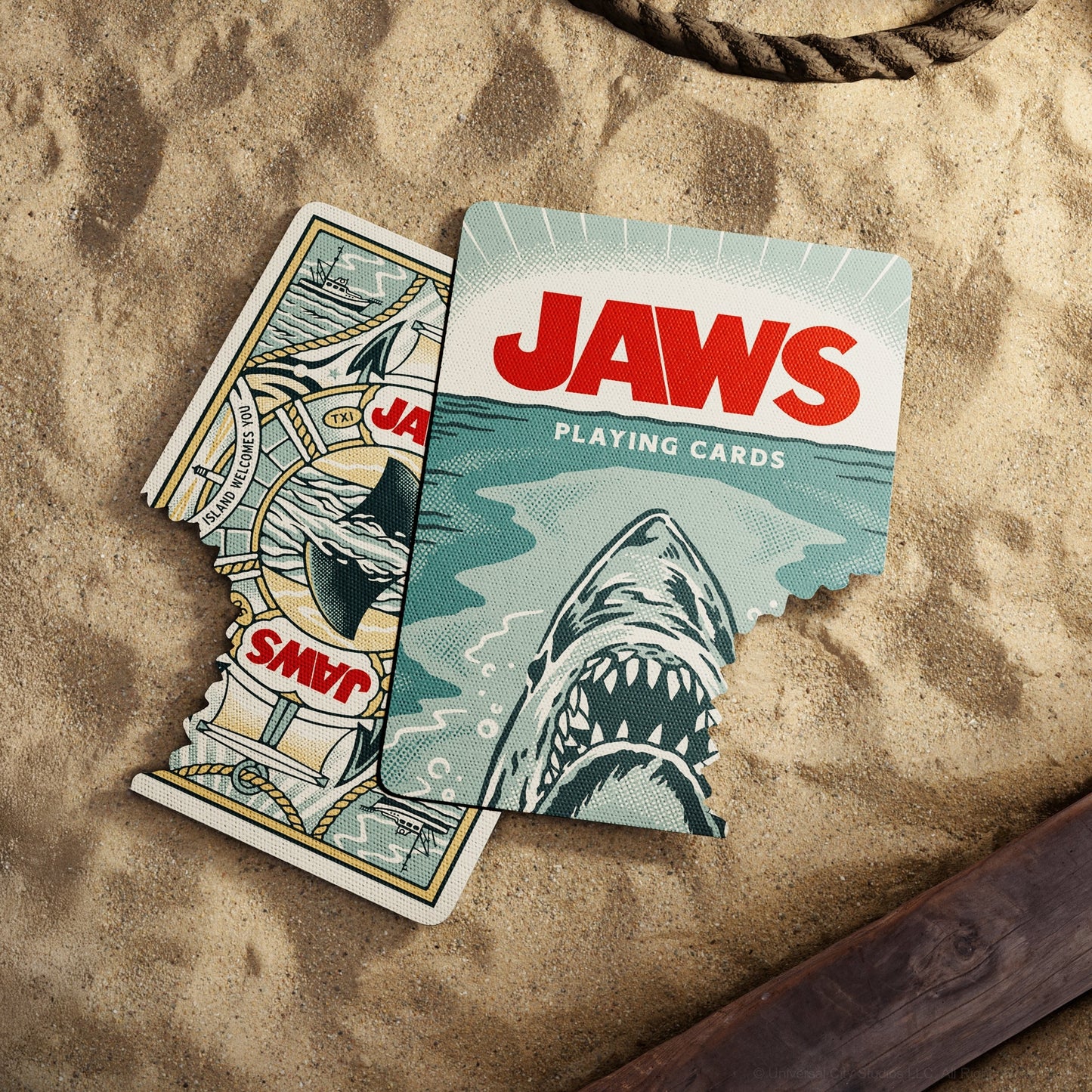 Playing cards deck box with shark artwork and JAWS text, with cards fanned beside