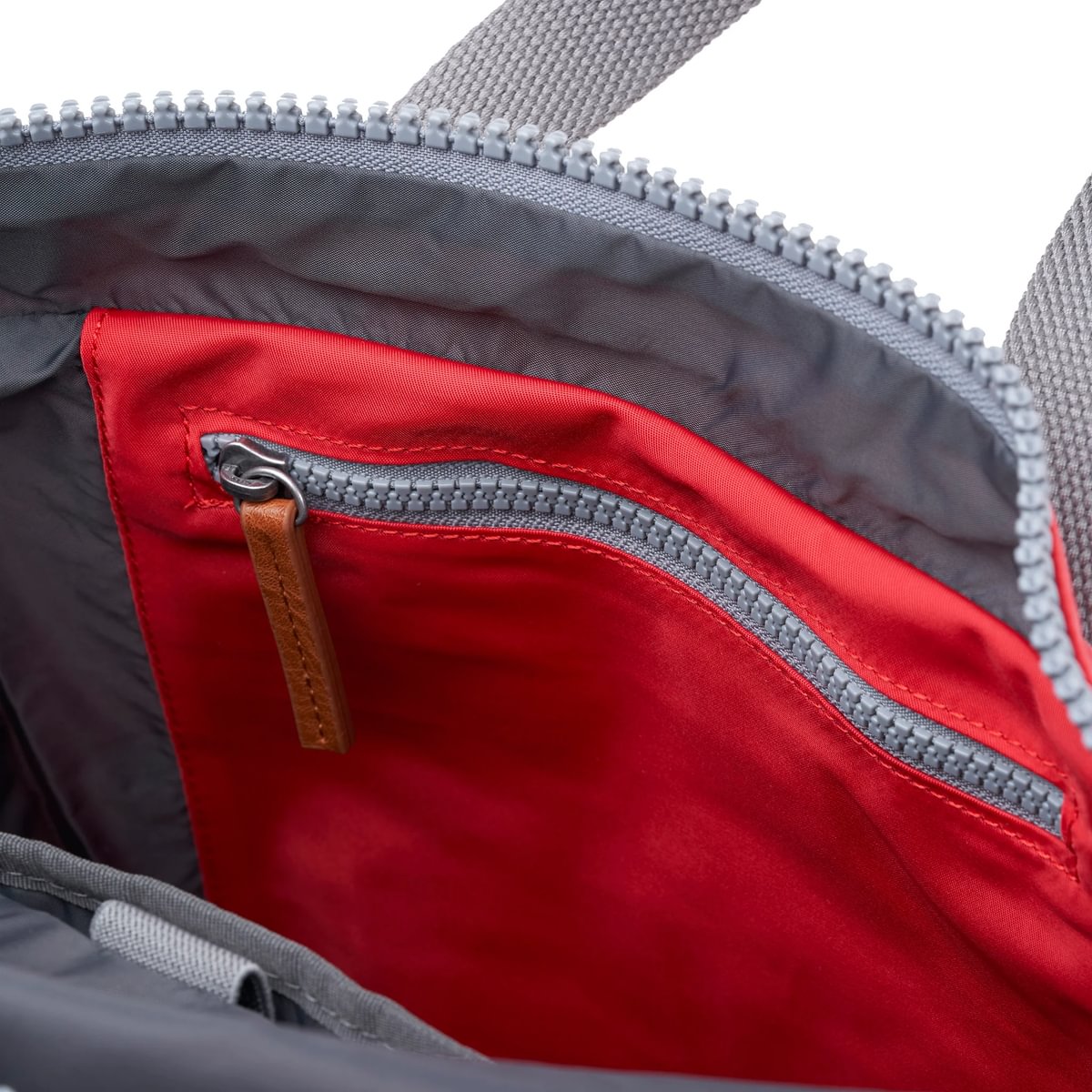 Red and gray nylon backpack interior with zipper and red lining detail