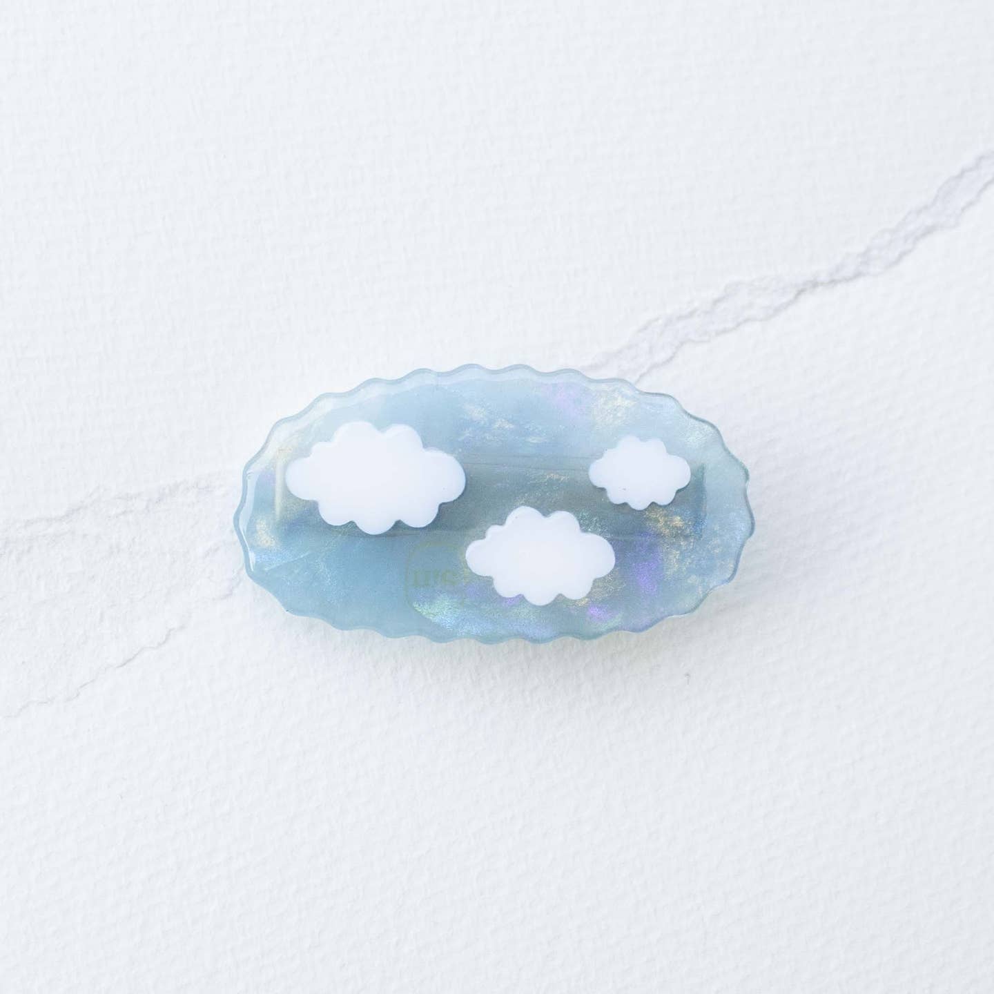 Acetate hair clip with sky-blue oval and white cloud cutouts