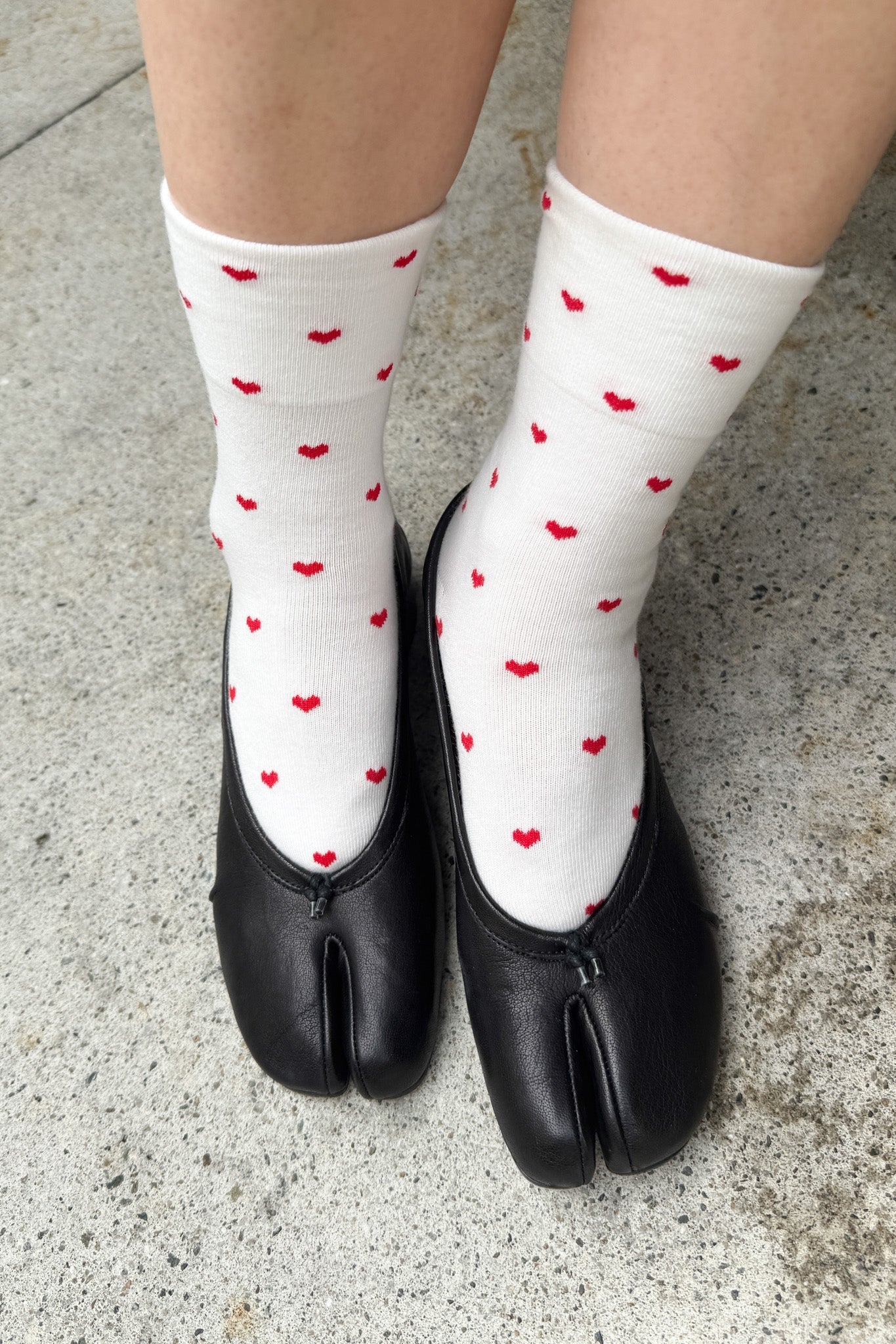 White sneaker socks with red hearts, worn with black shoes