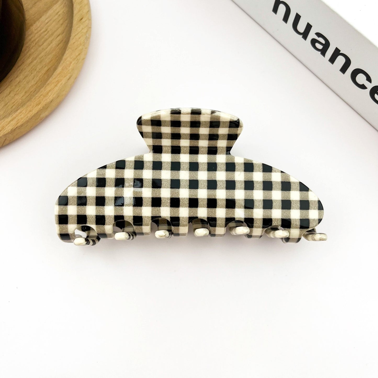 Black and cream checkered acetate hair claw clip with ridged metal teeth
