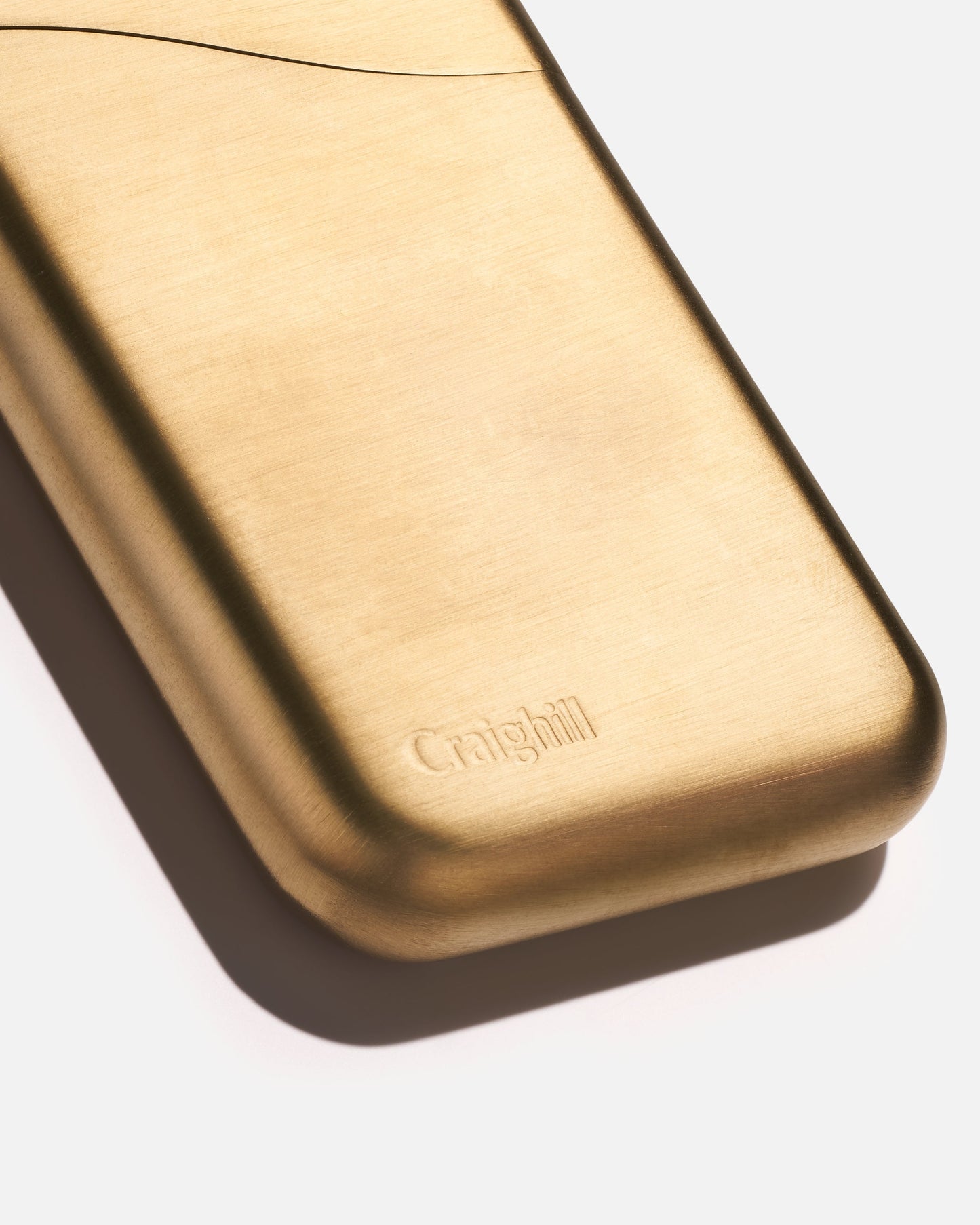 Summit card case close-up in vapor brass with embossed brand logo