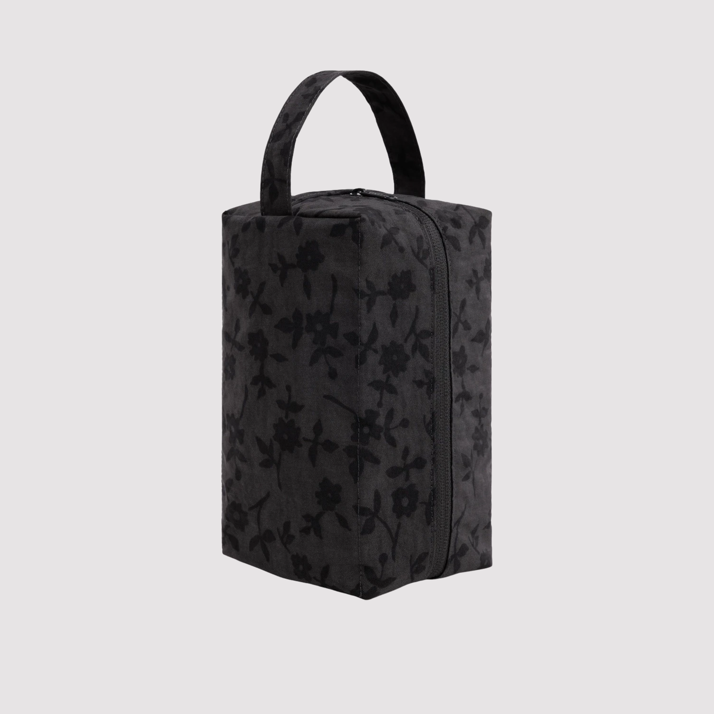Black patterned dopp kit with carry handles, structured boxy shape and zip closure