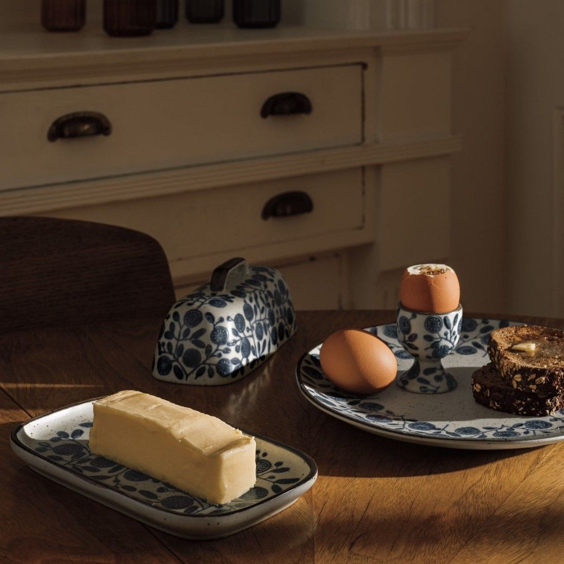 Ceramic butter dish with blue floral lid, holding a pat of butter