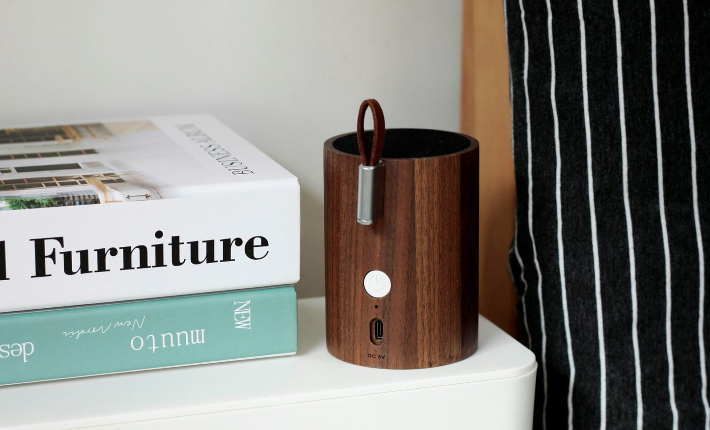 Walnut wood drum speaker with fabric top, metal handle, and front control ports