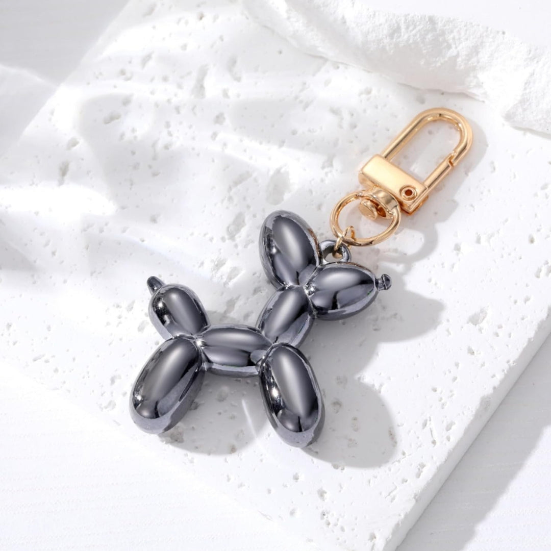 Dark gray metallic balloon dog keychain with gold clasp and split-ring attachment