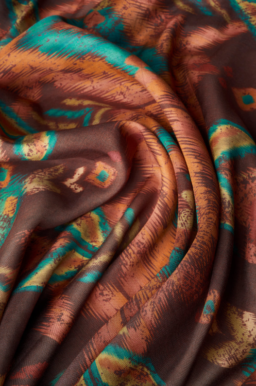 Batik fabric close-up in chocolate brown with teal brushstroke and tan accents