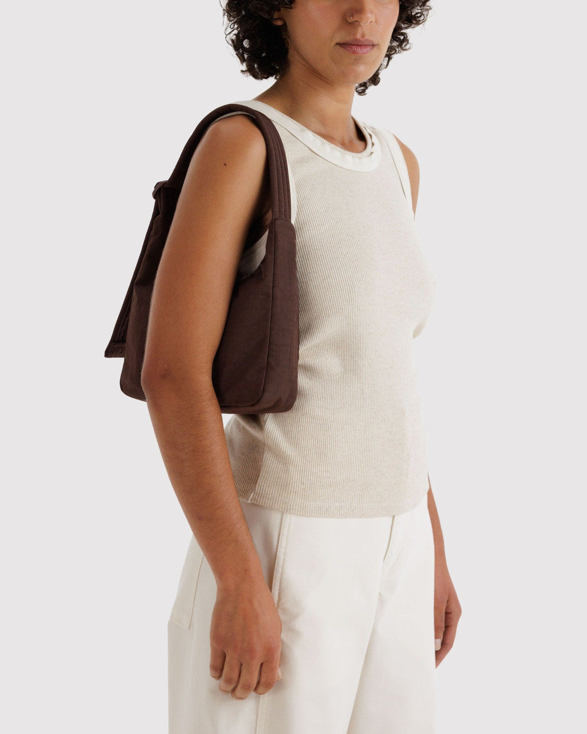 Dark brown mini nylon shoulder bag worn on the side with short strap