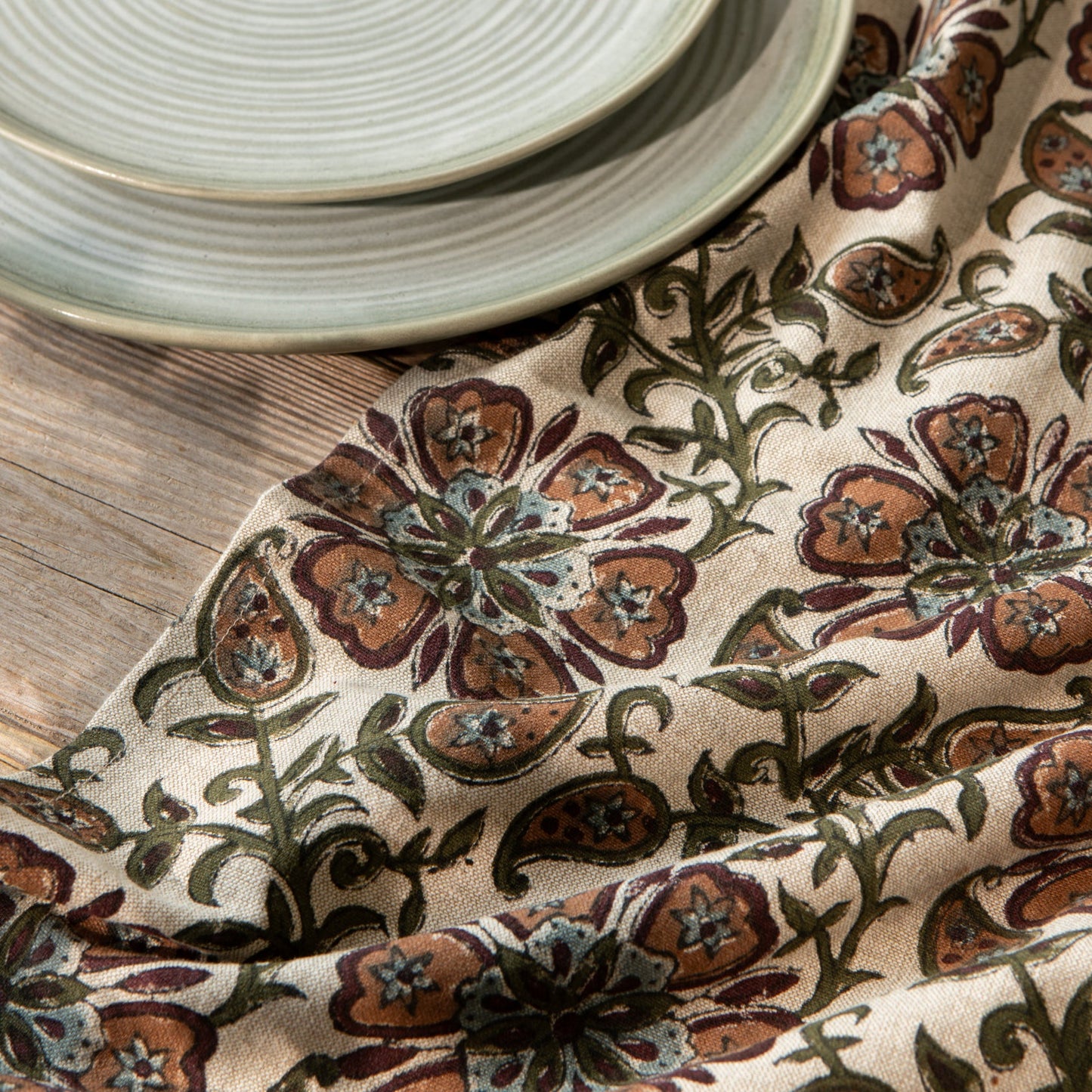 Cream floral block-print fabric dishtowel with brown, rust, and green vine motifs