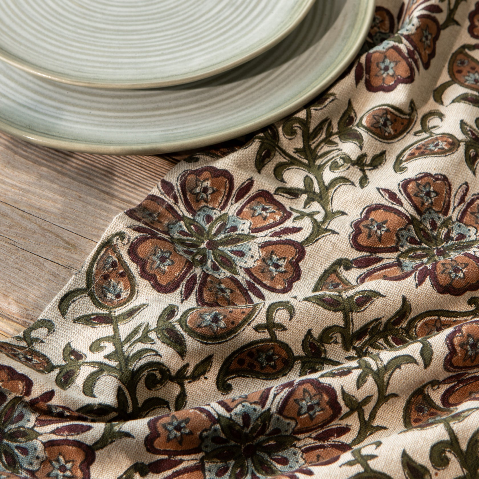 Cream floral block-print fabric dishtowel with brown, rust, and green vine motifs