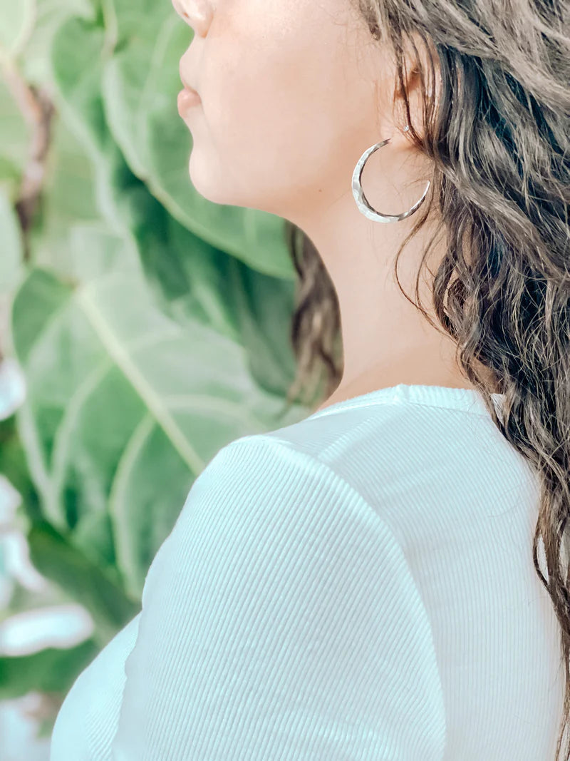 Silver hoop earrings worn on model, large round open-hoop design