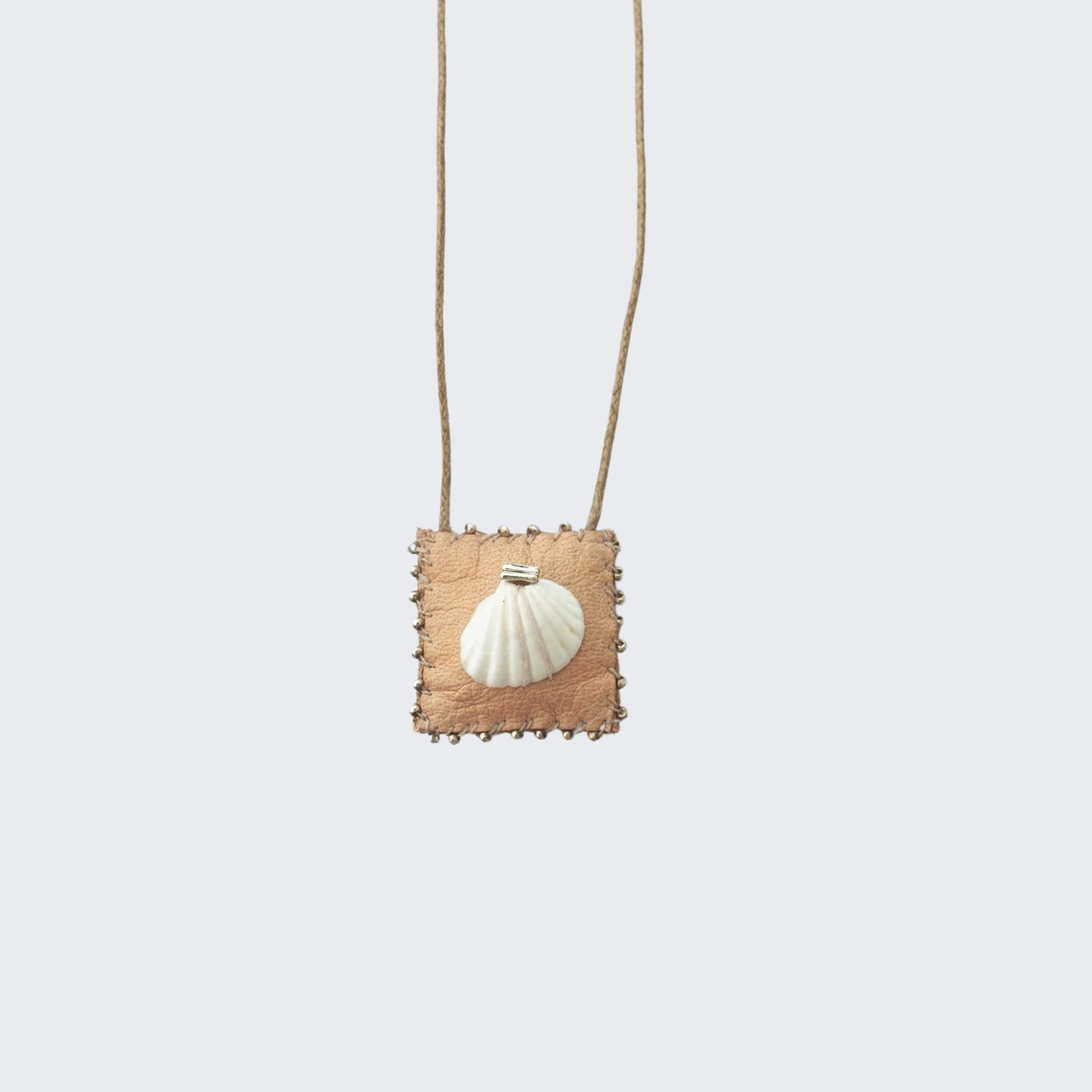 Talisman necklace with square tan pendant and white seashell on thin gold chain