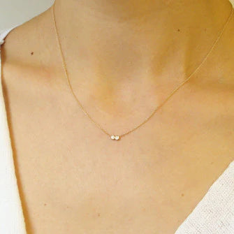 14k gold necklace worn on model, small round diamond pendant