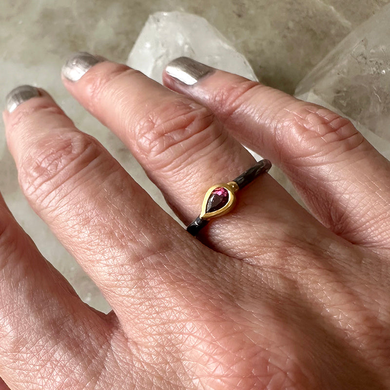 Oxidized silver ring with pink tourmaline and gold vermeil bezel worn on finger