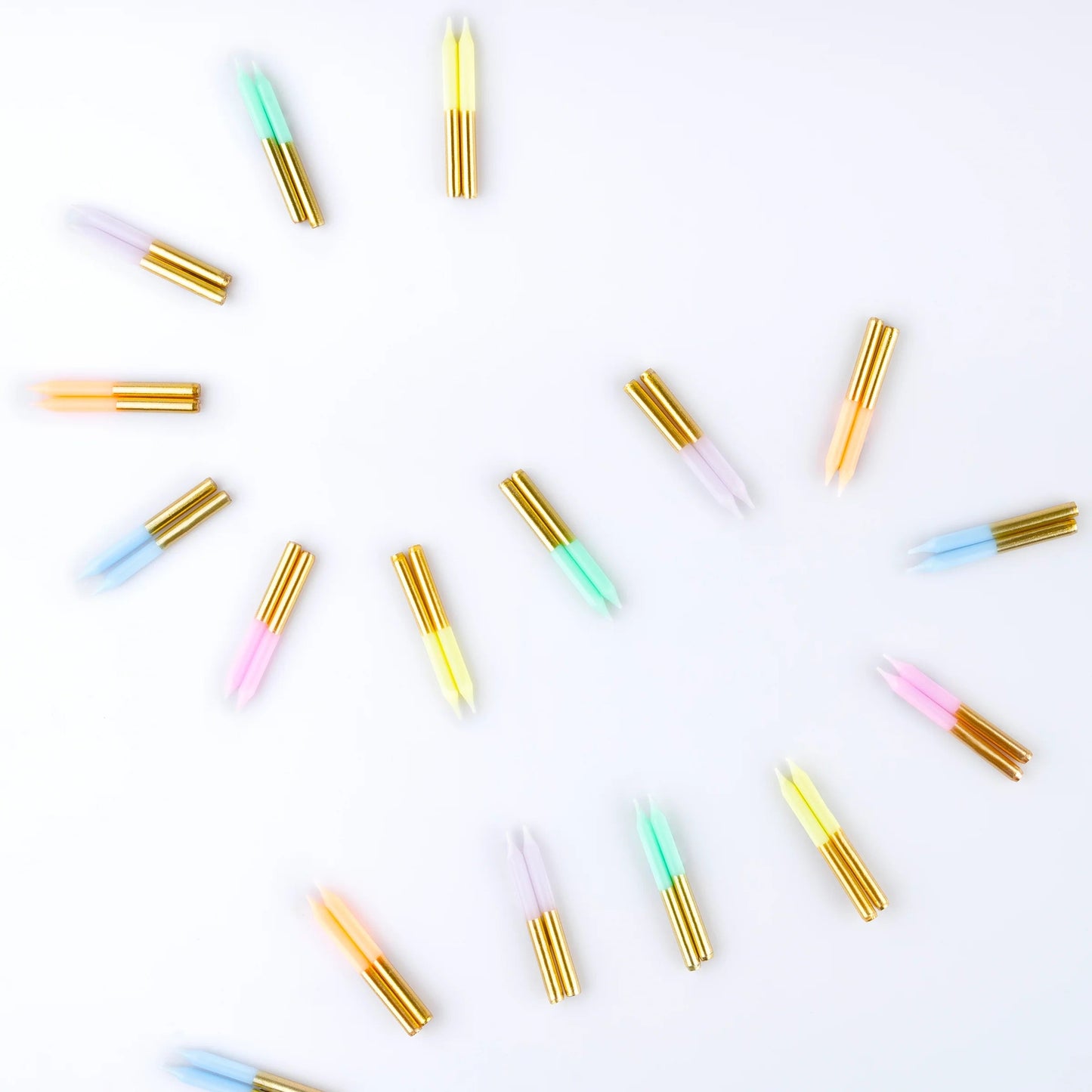Pastel mini candles scattered, gold wicks, striped pastel wax tips