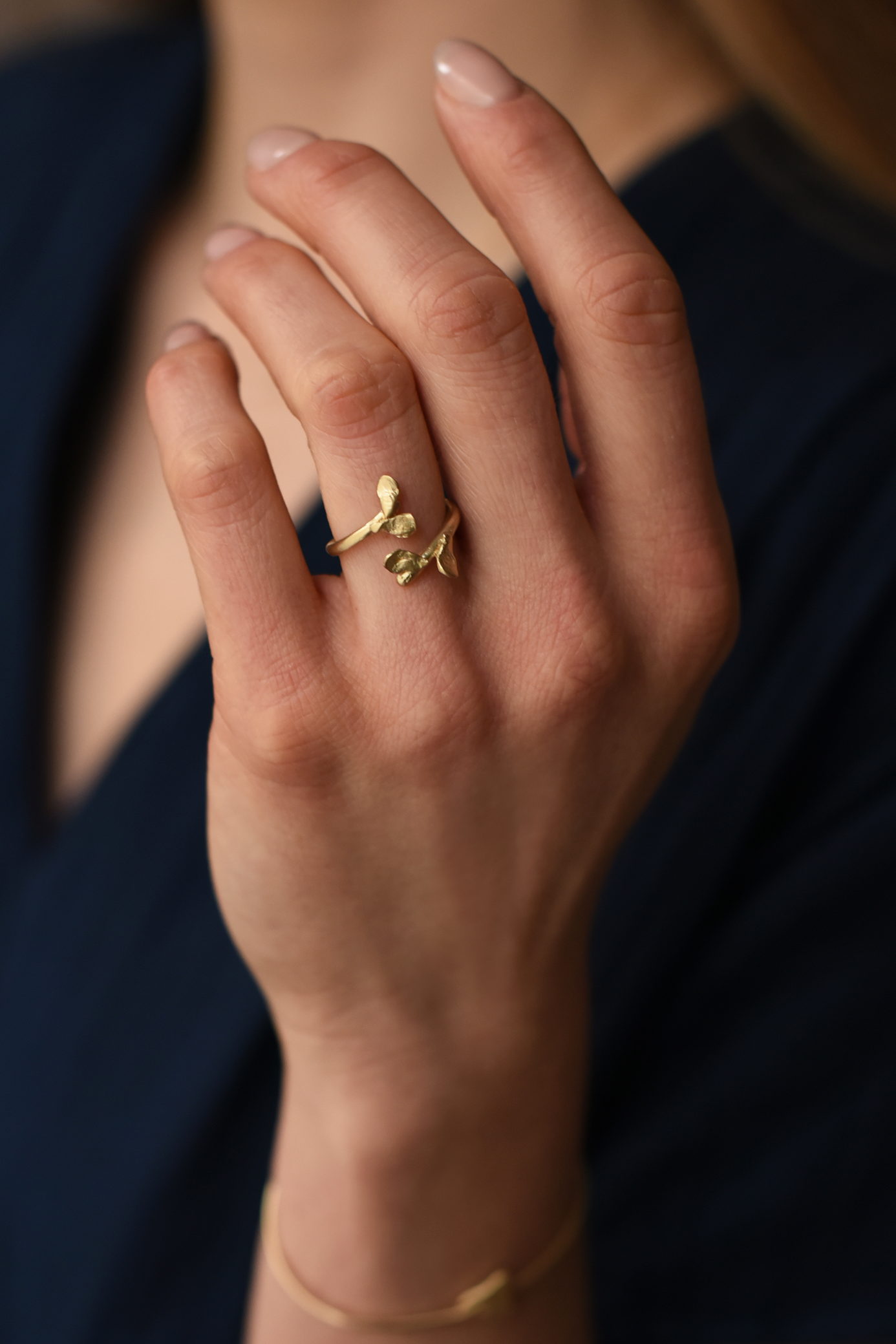 Brass leaf open ring on hand, small sculpted leaf motif on slim band