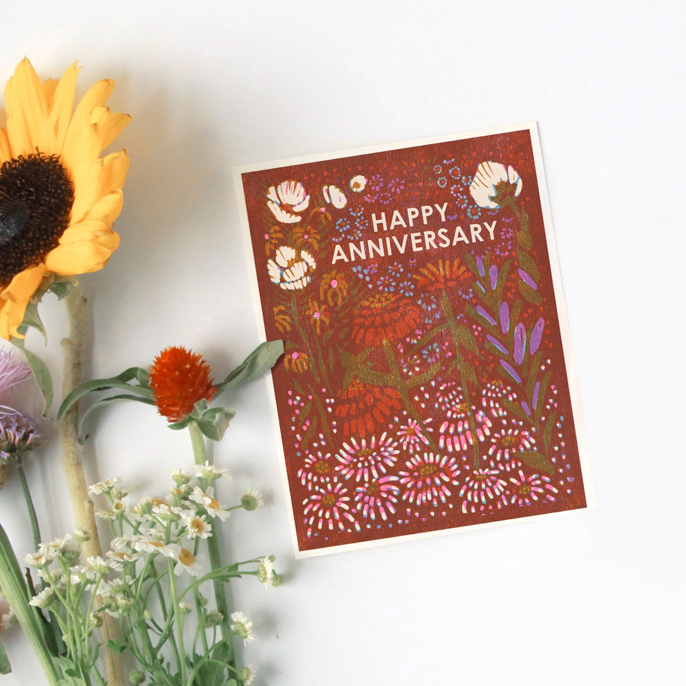 Anniversary letterpress greeting card with dark red artwork and white 'Happy Anniversary' lettering