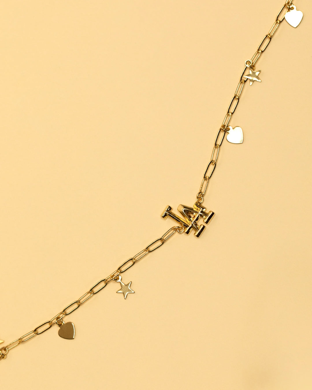 Gold chain necklace with star, heart, and logo charms
