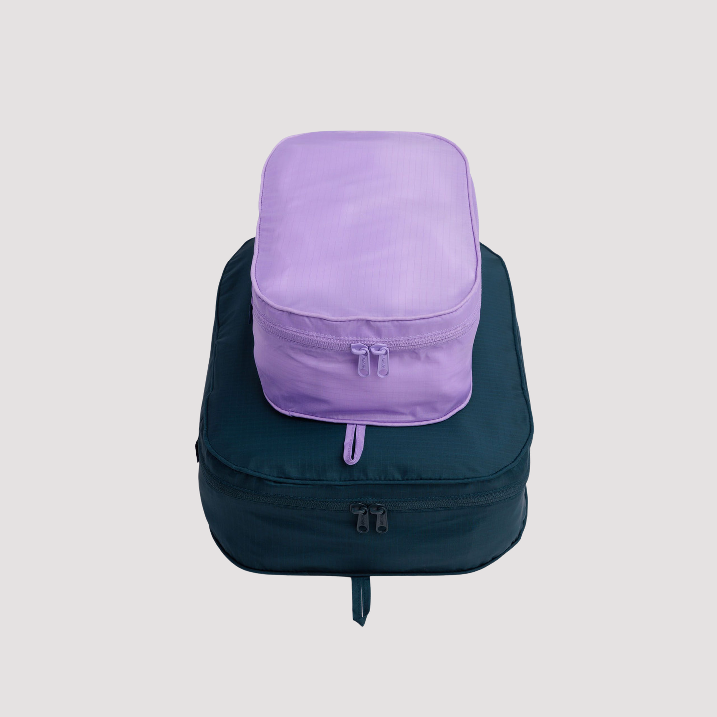 Packing cube set in dark teal with lavender front pocket panel and zip closure