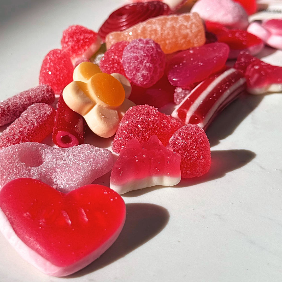 Heart-shaped red and pink gummy candies with sugar crystals