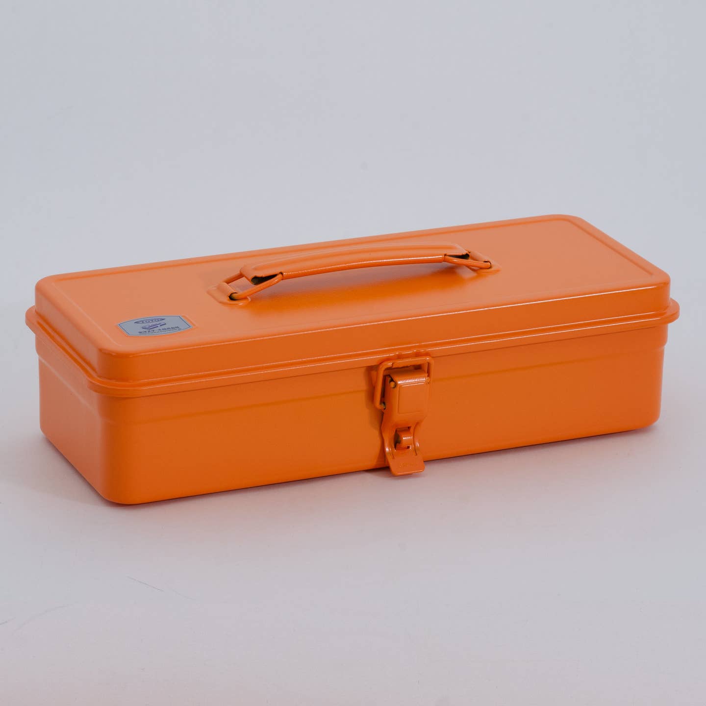 Orange steel toolbox with top handle, flat lid, and front metal latch