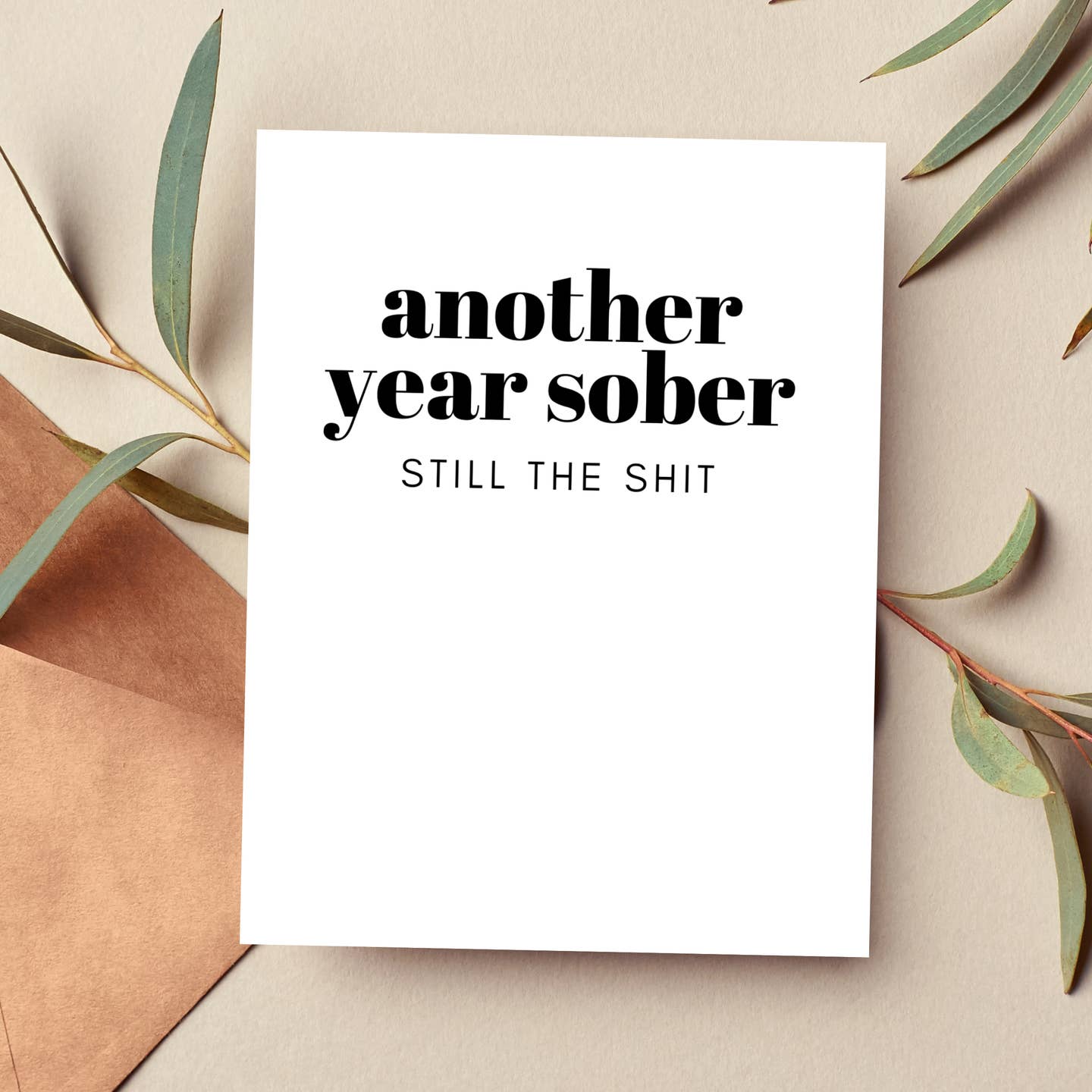 White greeting card with "another year sober" and "STILL THE SHIT" text