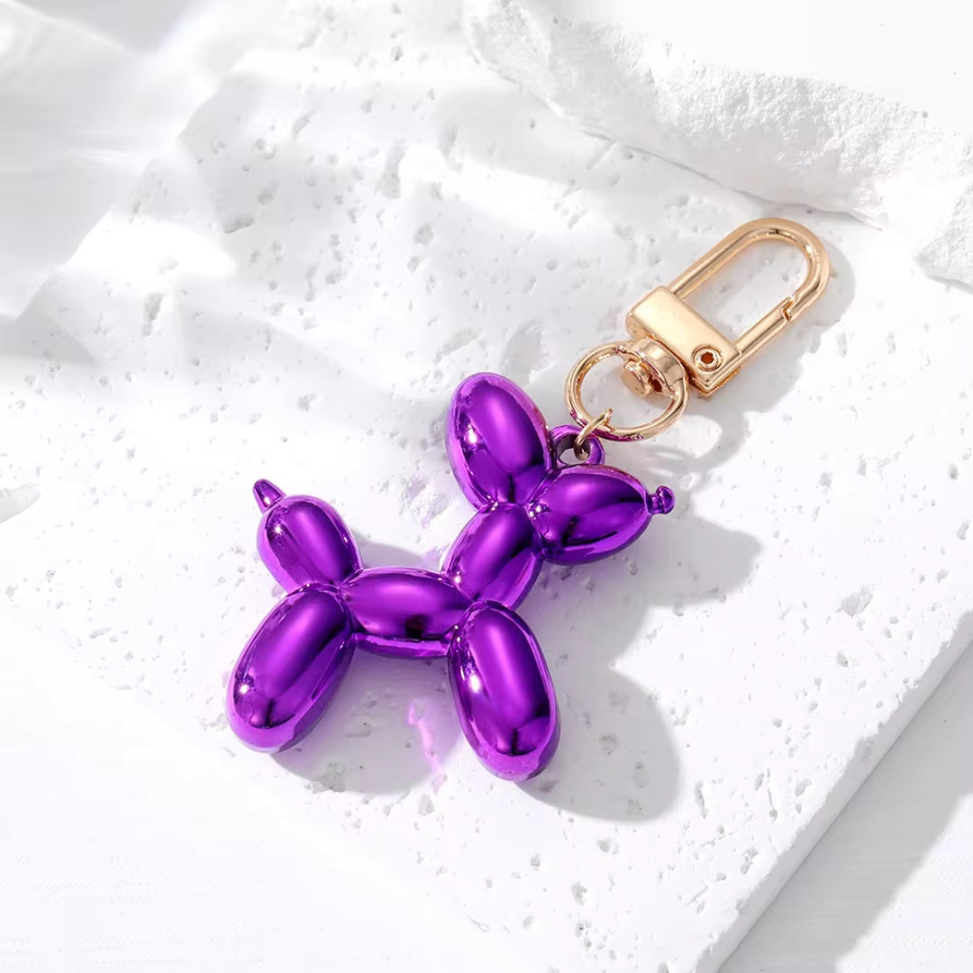 Violet-purple metallic balloon dog keychain with gold clasp and split-ring attachment