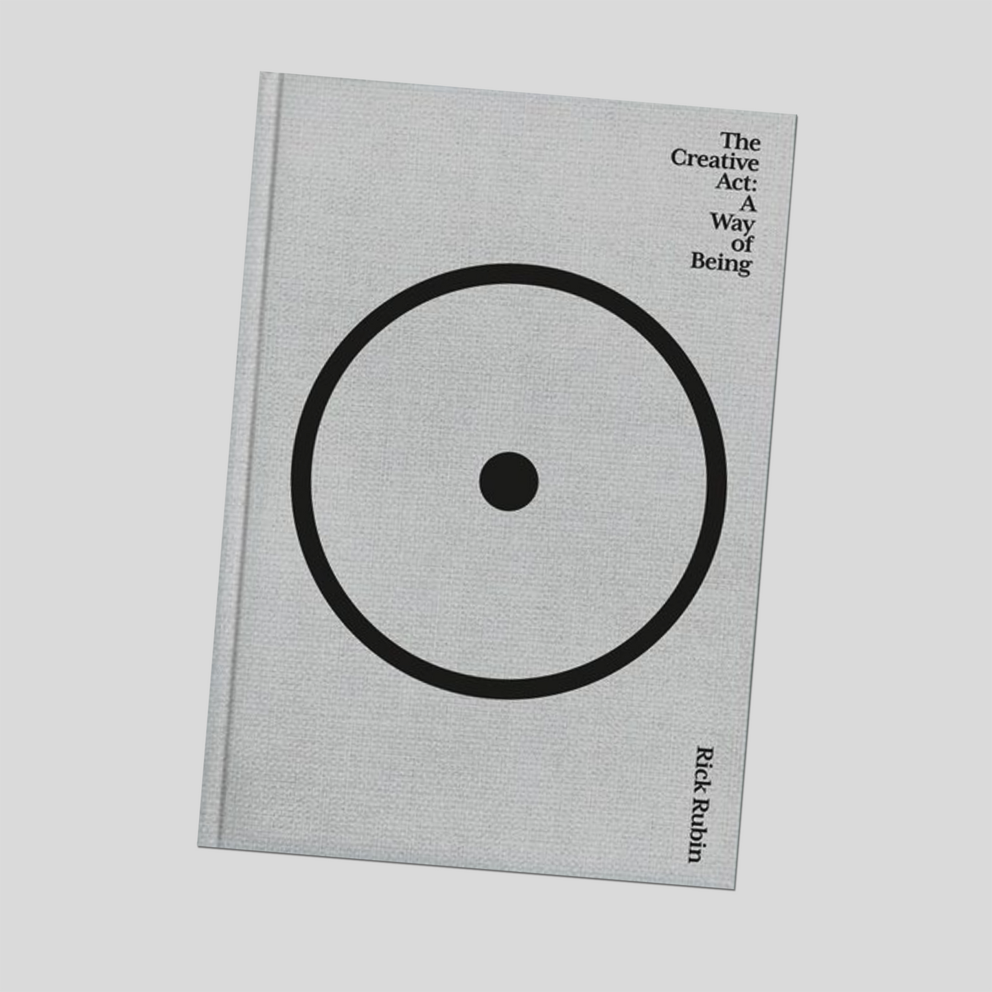 Hardcover book with grey cover, large black circle graphic, small title text on front