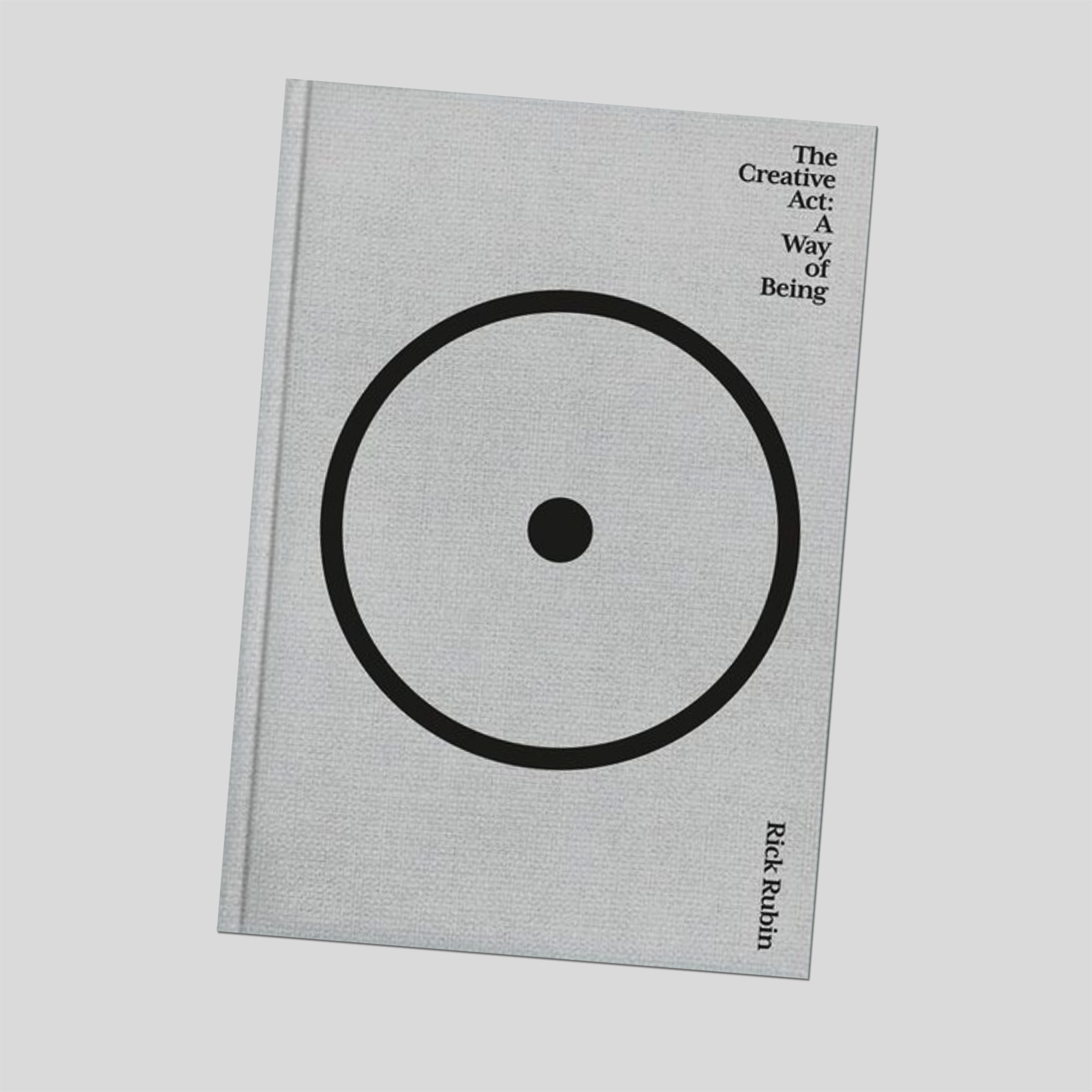 Hardcover book with grey cover, large black circle graphic, small title text on front