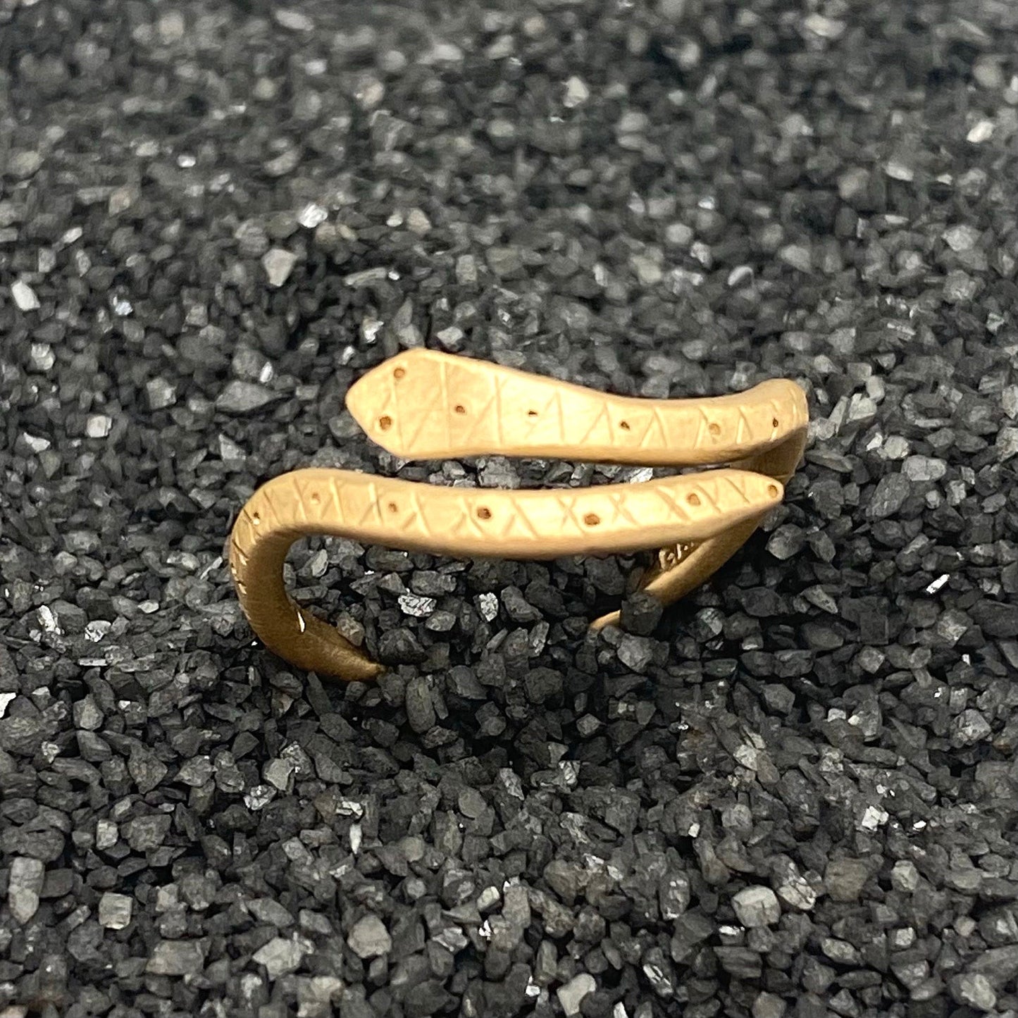 Matte brass snake ring with engraved symbol bands, two rings stacked