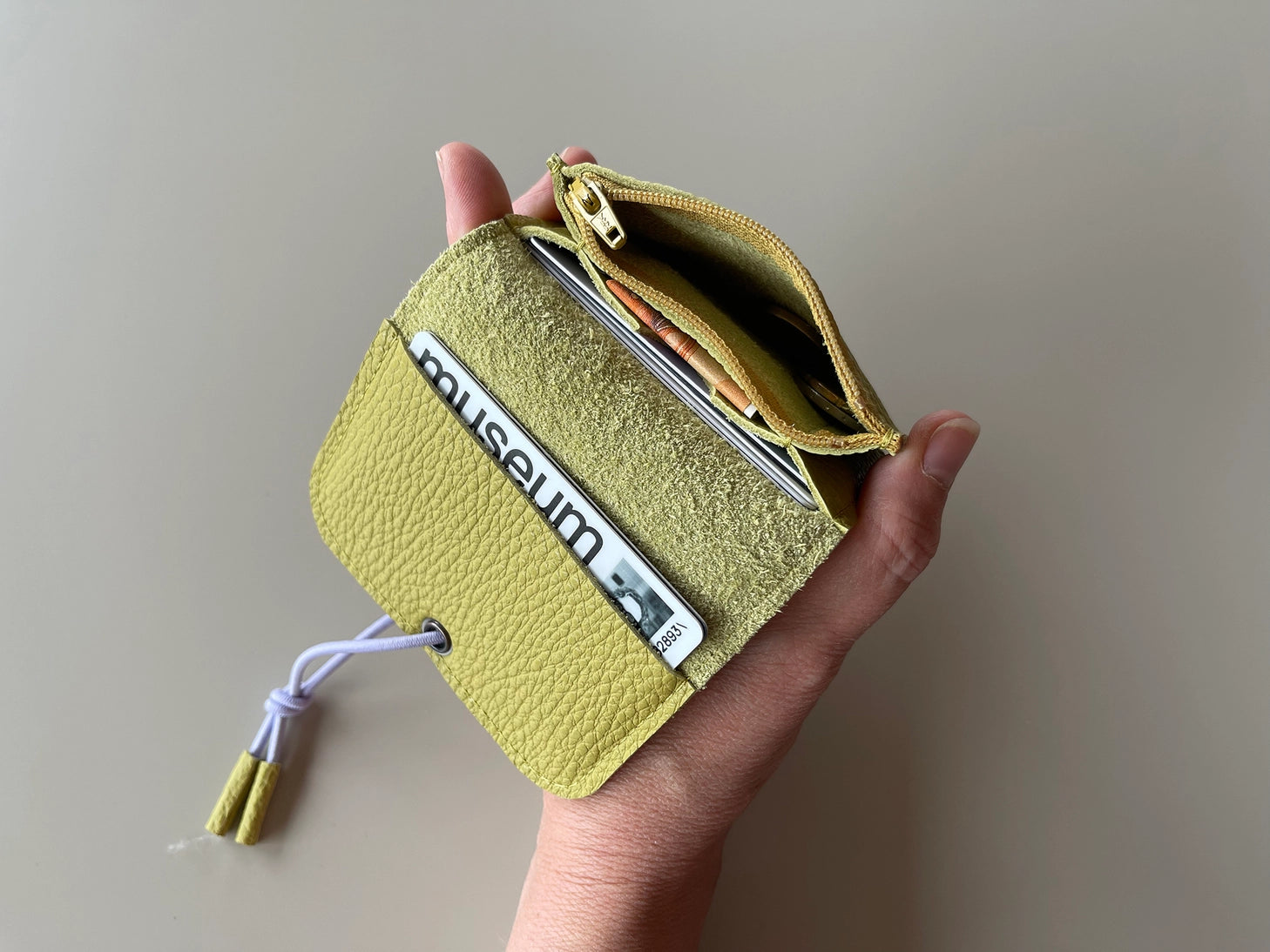 Olive leather mini wallet with knot closure, showing card slots and bill pocket