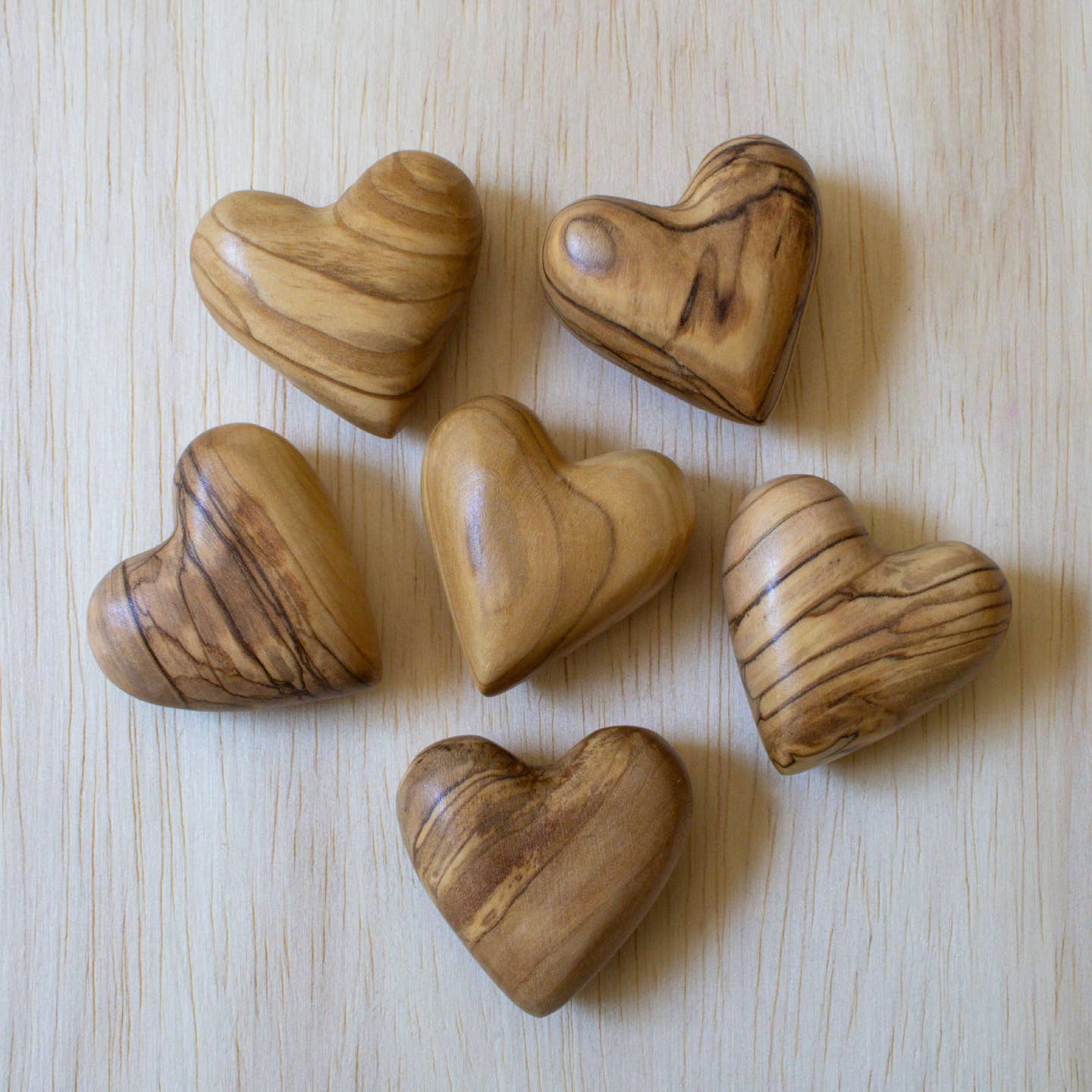Olive wood heart-shaped carved pieces, assorted natural brown tones with visible grain.