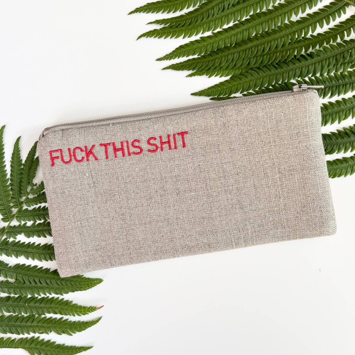 Small gray fabric pouch with zipper and red printed text