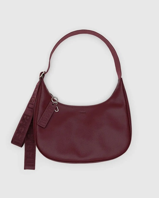 Medium recycled leather crescent bag in burgundy, zip top, shoulder strap with tassel