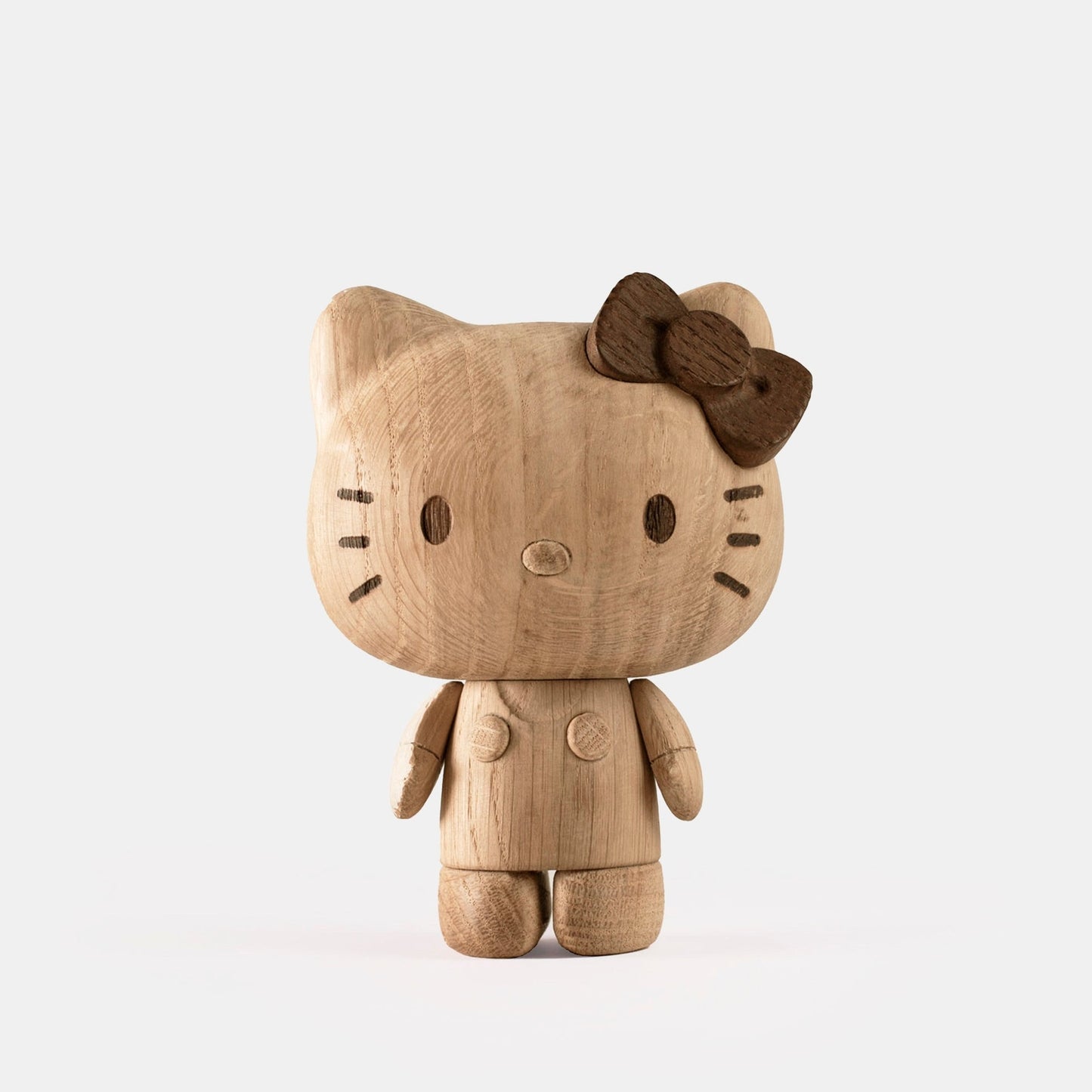 Hello Kitty wooden figurine with bow, angled side view, carved face and paws