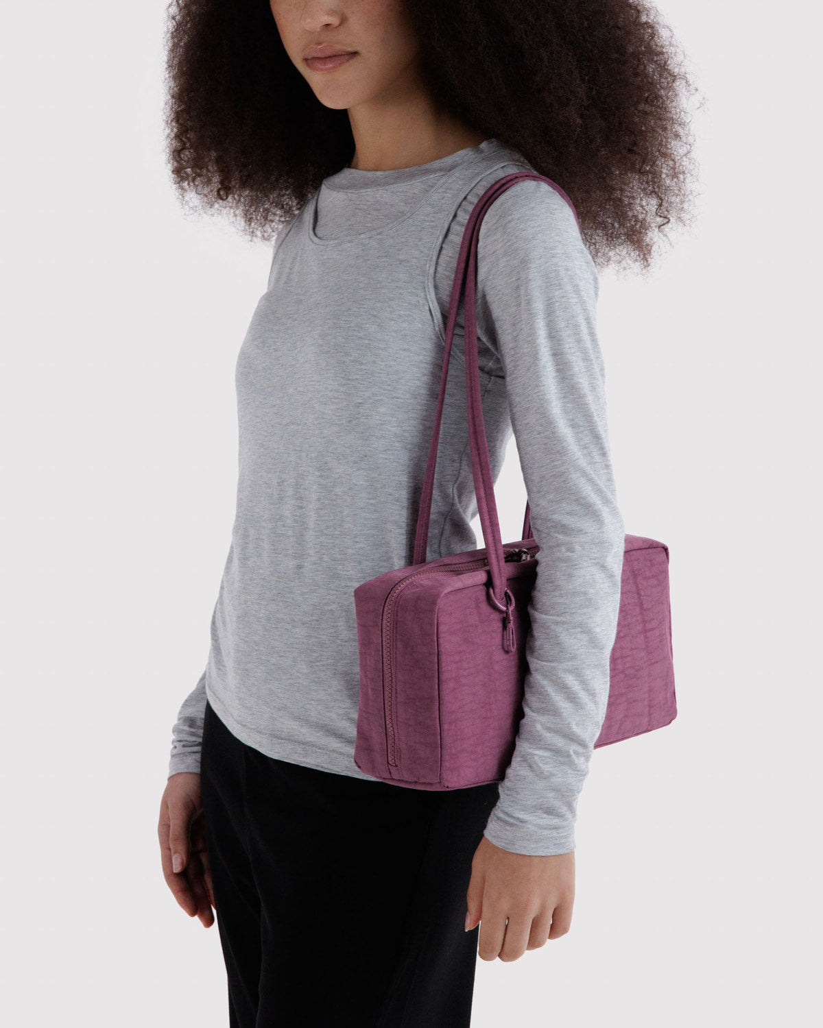 Nylon bowler bag in plum purple with long shoulder handles and zip closure